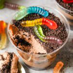 Overhead view of a cup of dirt pudding with one bite missing.