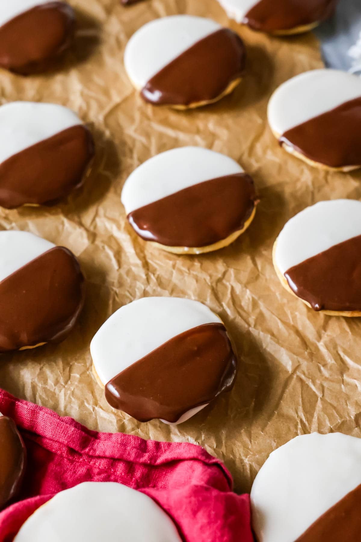 Homemade black and white cookies on brown parchment paper.