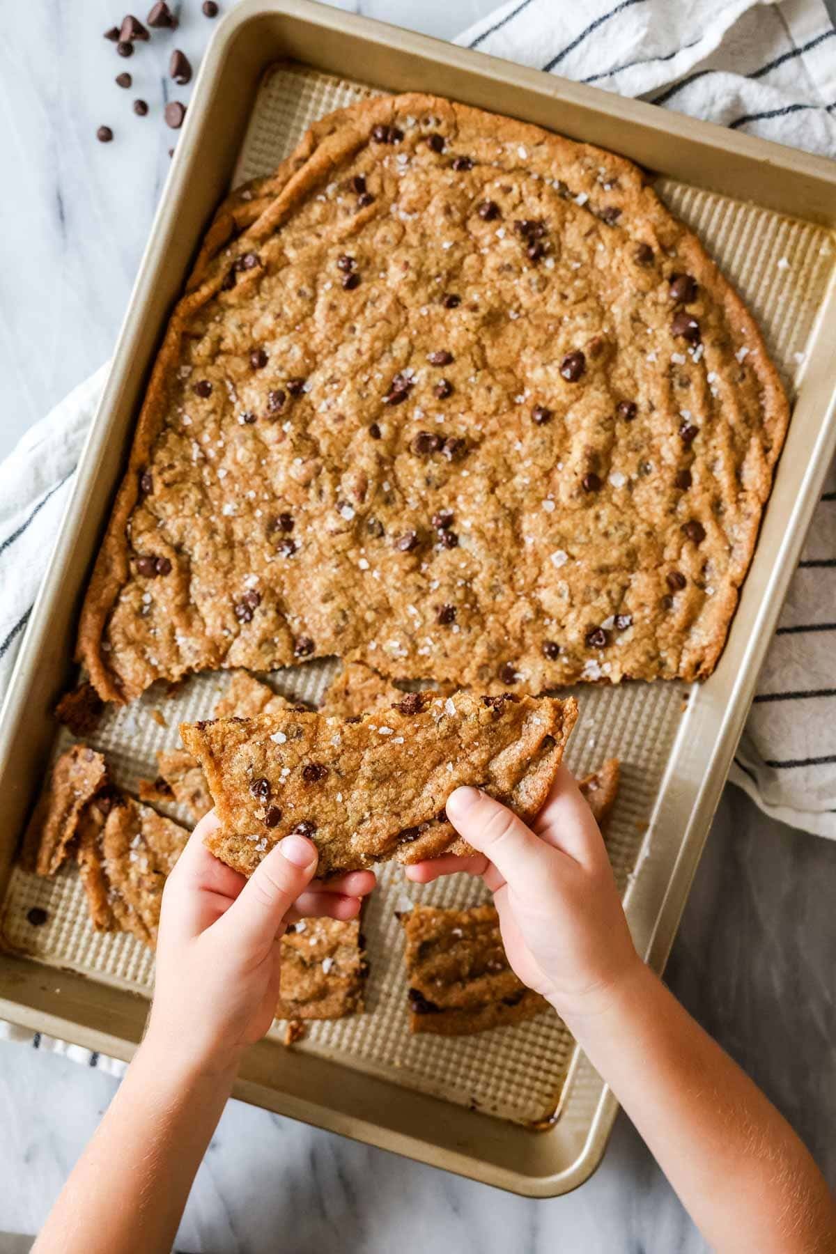 Hands breaking up cookie brittle.
