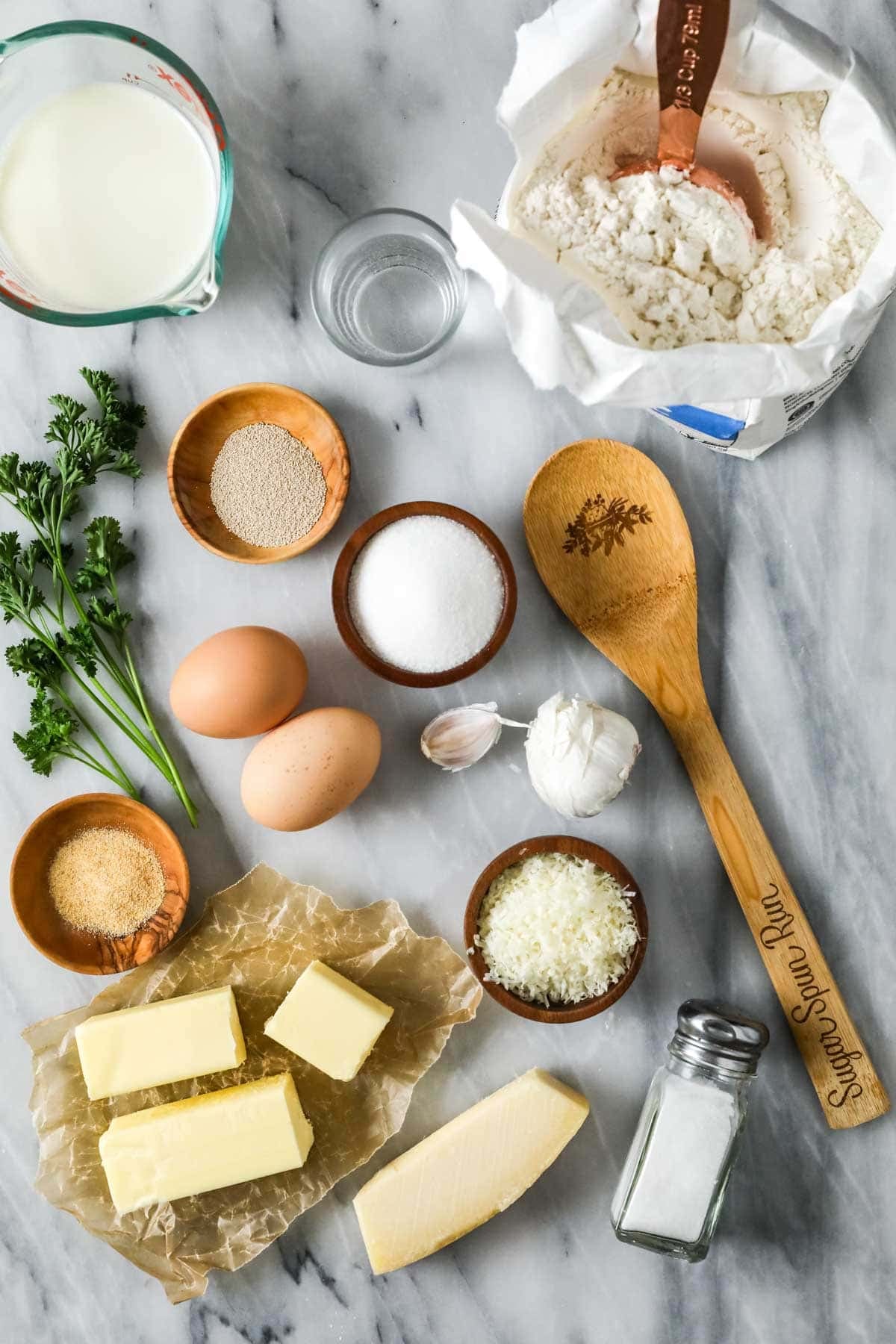 Overhead view of ingredients including butter, garlic, yeast, and more.