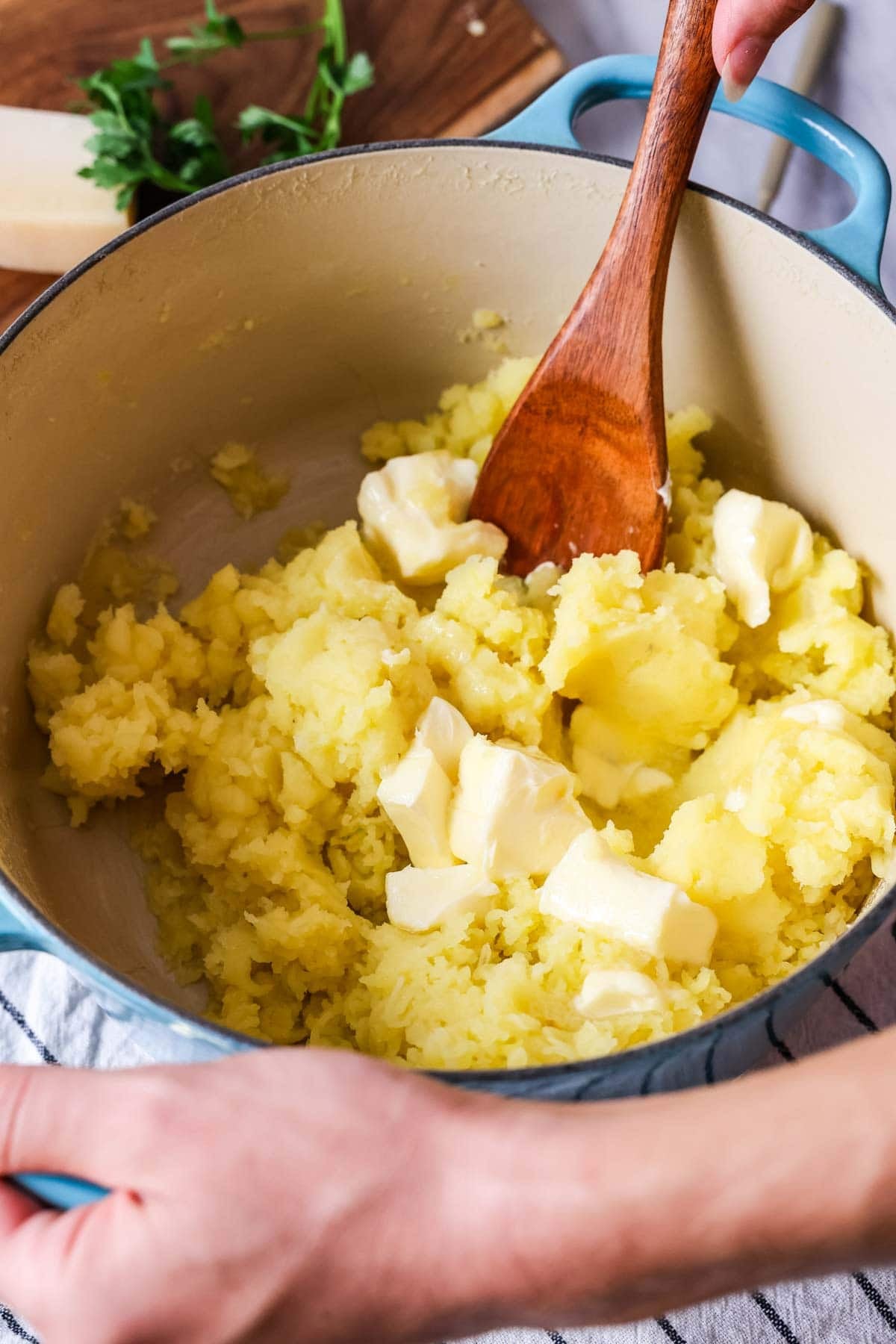 Butter being stirred into potatoes after mashing.