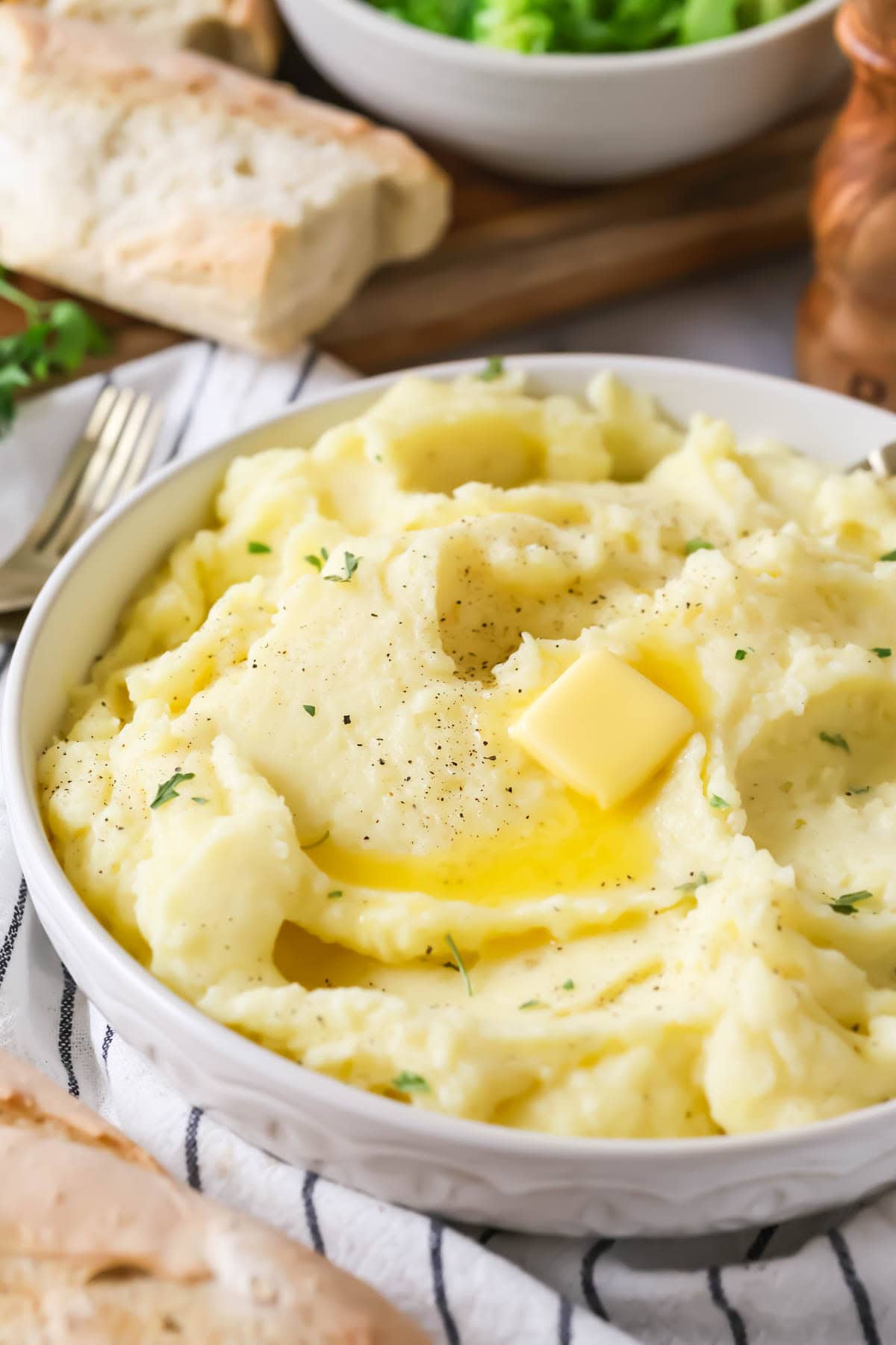 Bowl of my mashed potatoes recipe topped with a melting pat of butter.