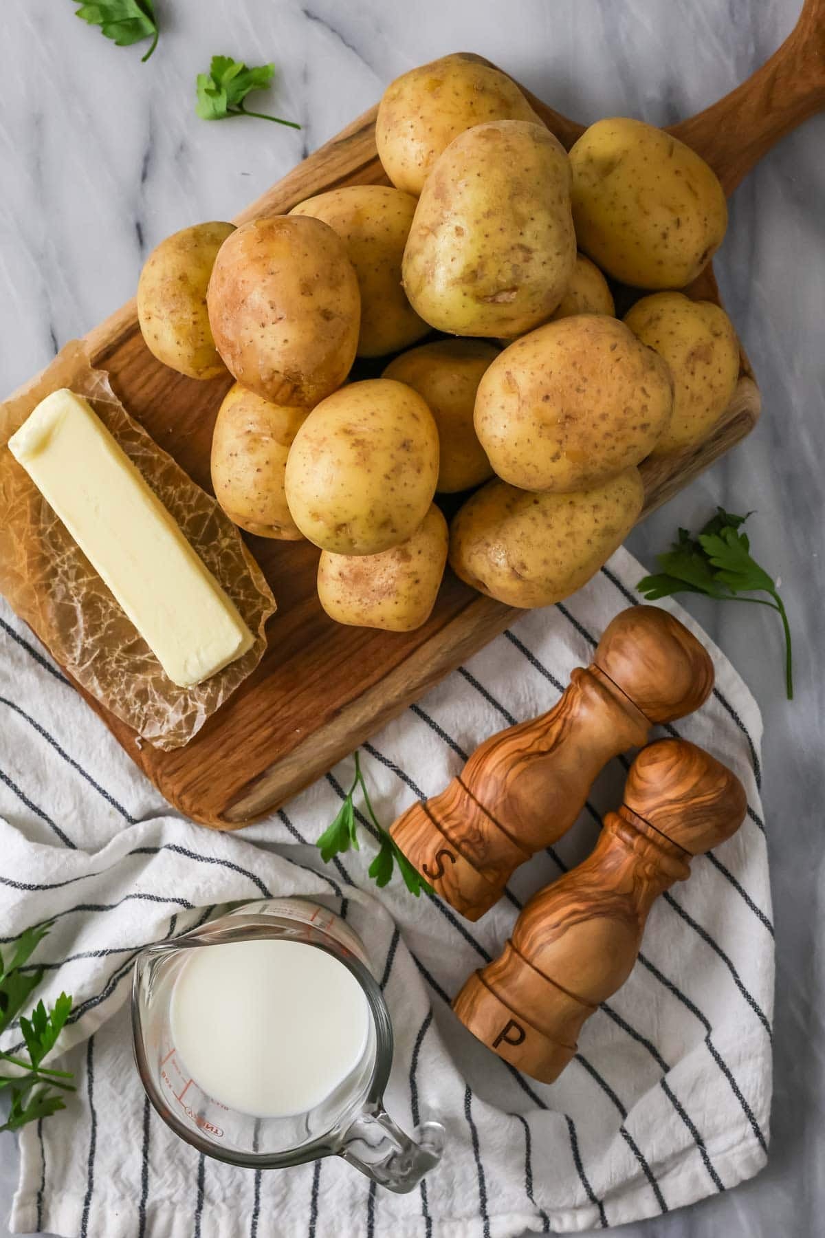 Overhead view of ingredients including potatoes, butter, milk, and more.