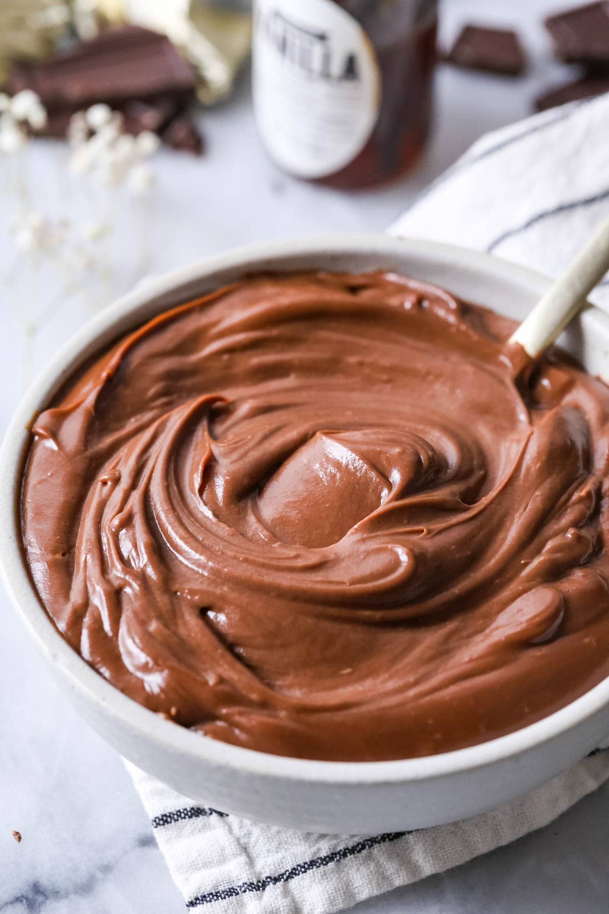 Bowl of chocolate pastry cream thats been stirred into a thick swirl.