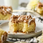 Bite missing from a slice of sourdough coffee cake on a white plate.