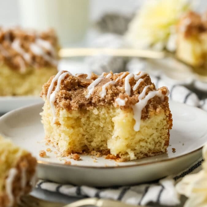 Bite missing from a slice of sourdough coffee cake on a white plate.