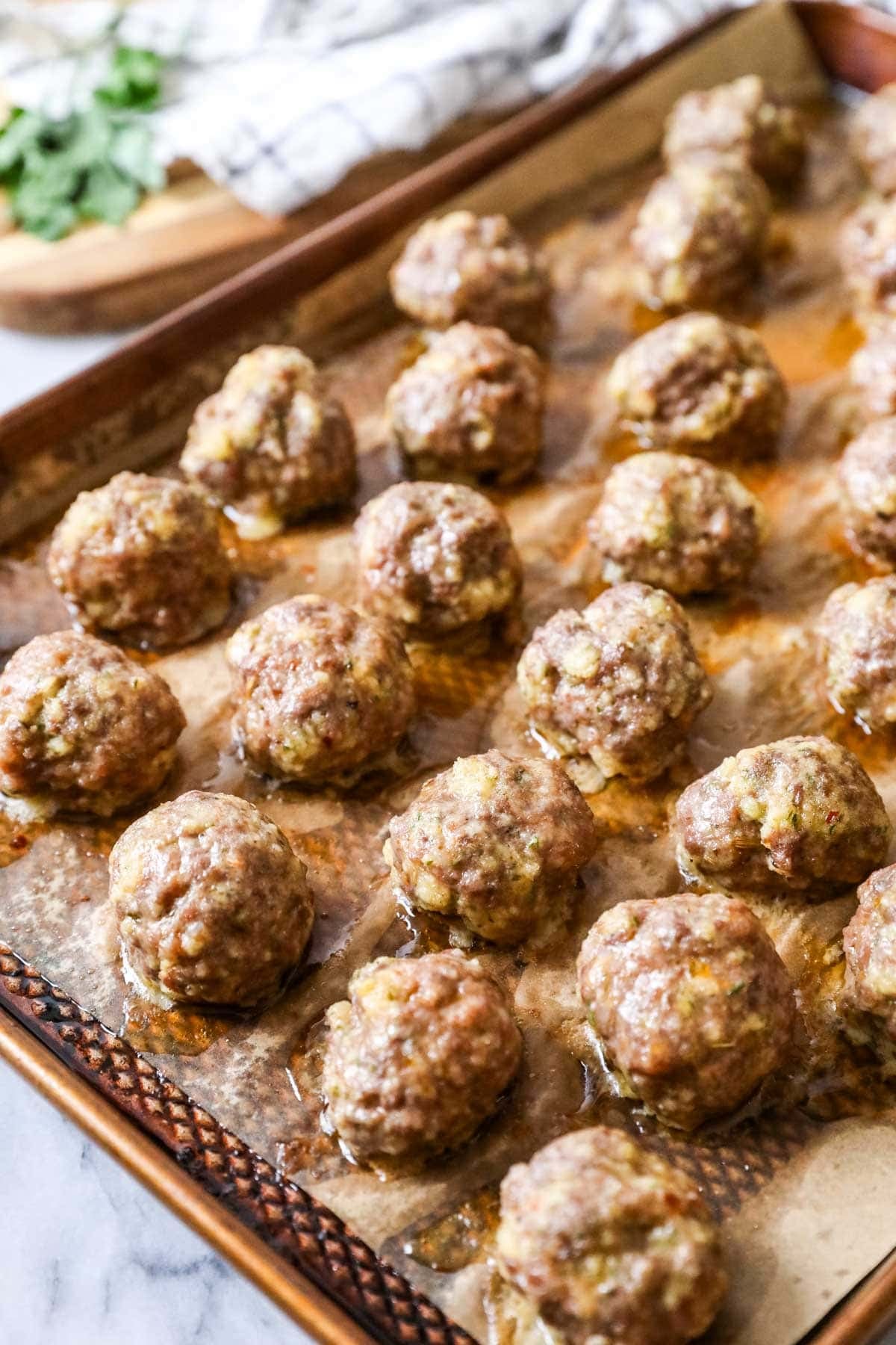 Meatballs on a baking sheet after baking.