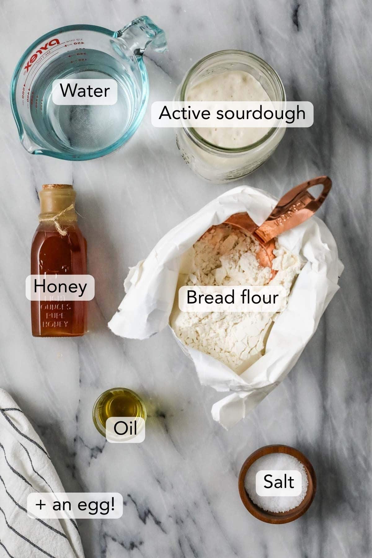 Overhead view of ingredients for my sourdough bagels recipe including honey, bread flour, sourdough starter, and more.