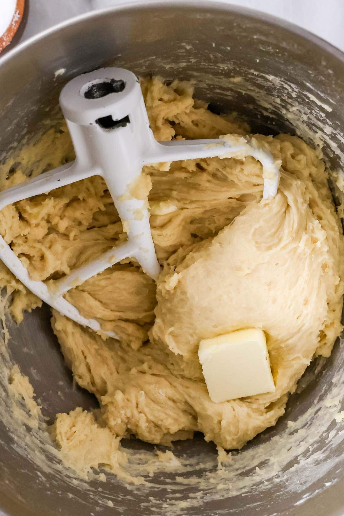 Butter being mixed into a yeast dough one tablespoon at a time.