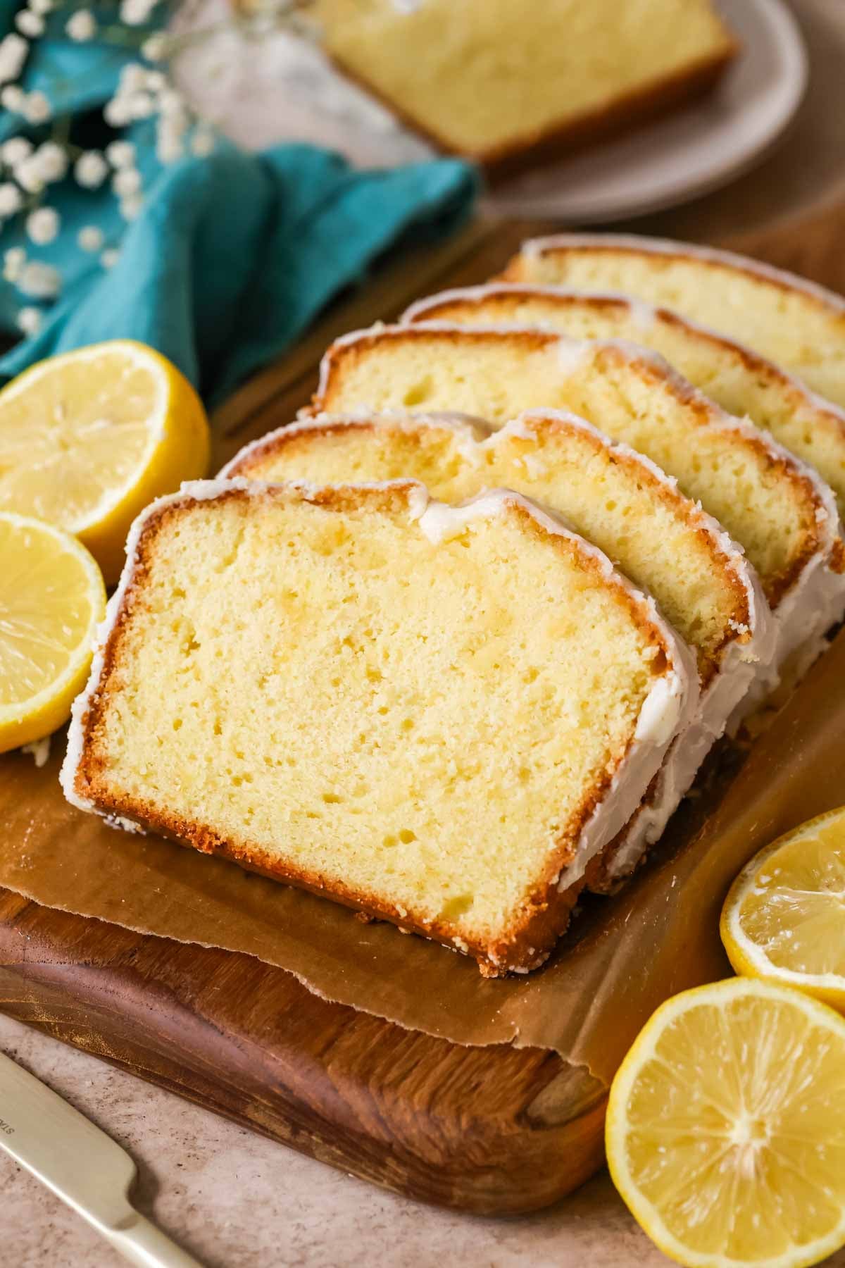 Slices of lemon pound cake stacked against each other on a cutting board.