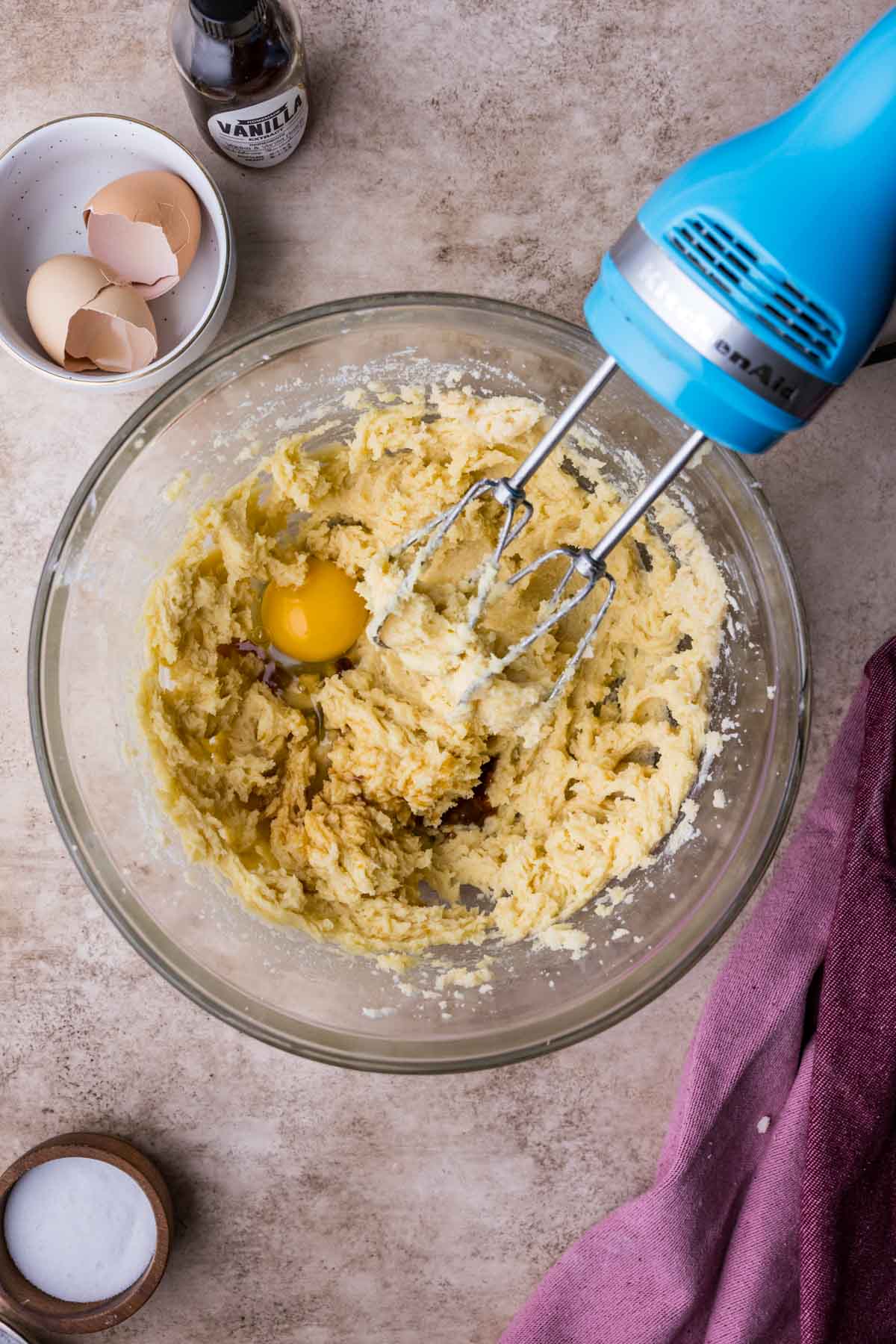 Eggs being stirred into a creamed butter mixture.