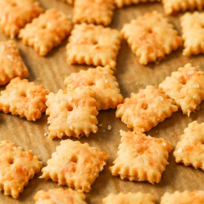 Close-up view of sourdough cheese crackers on a baking sheet.
