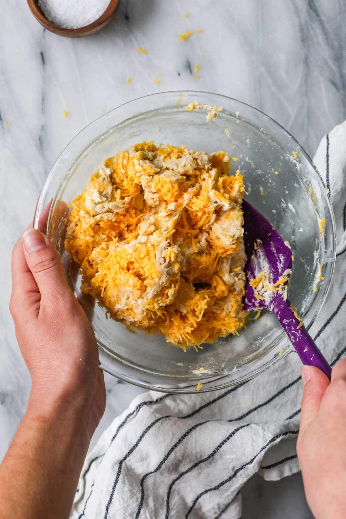 Spatula stirring a cheese cracker dough together.