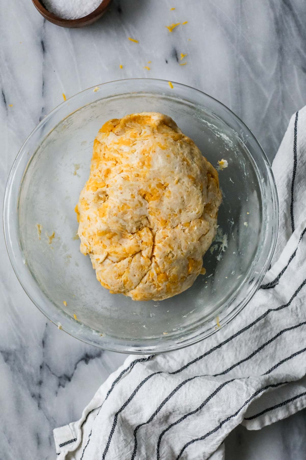 Overhead view of a cheese cracker dough in a bowl after mixing.
