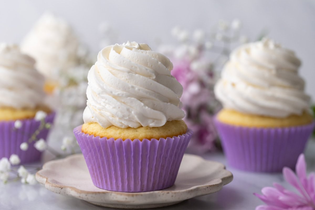 Cupcakes topped with tall swirls of swiss meringue buttercream frosting.