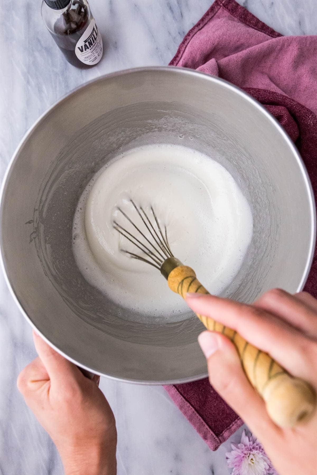 Overhead view of a meringue mixture that's turned opaque and thickened over a double boiler.